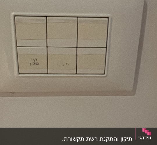מתג חשמלי על קיר בצבע לבן